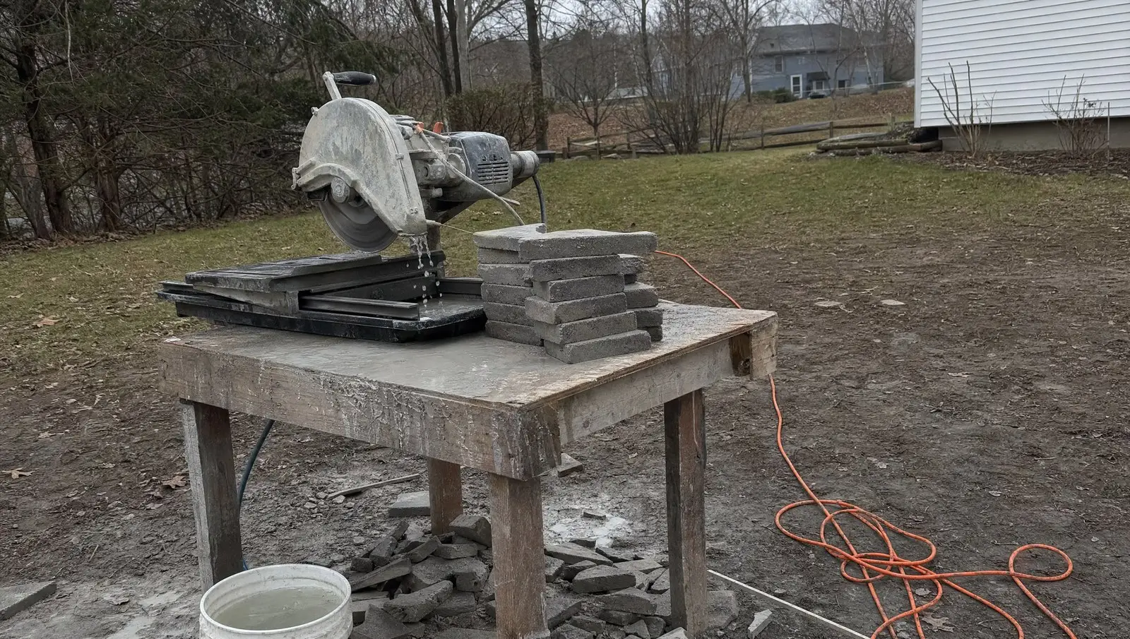Paver patio contractor Connecticut crew cutting pavers at a wet saw station
