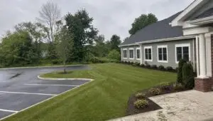 Freshly maintained grounds at a Connecticut commercial property with striped mowing lines and edged beds.
