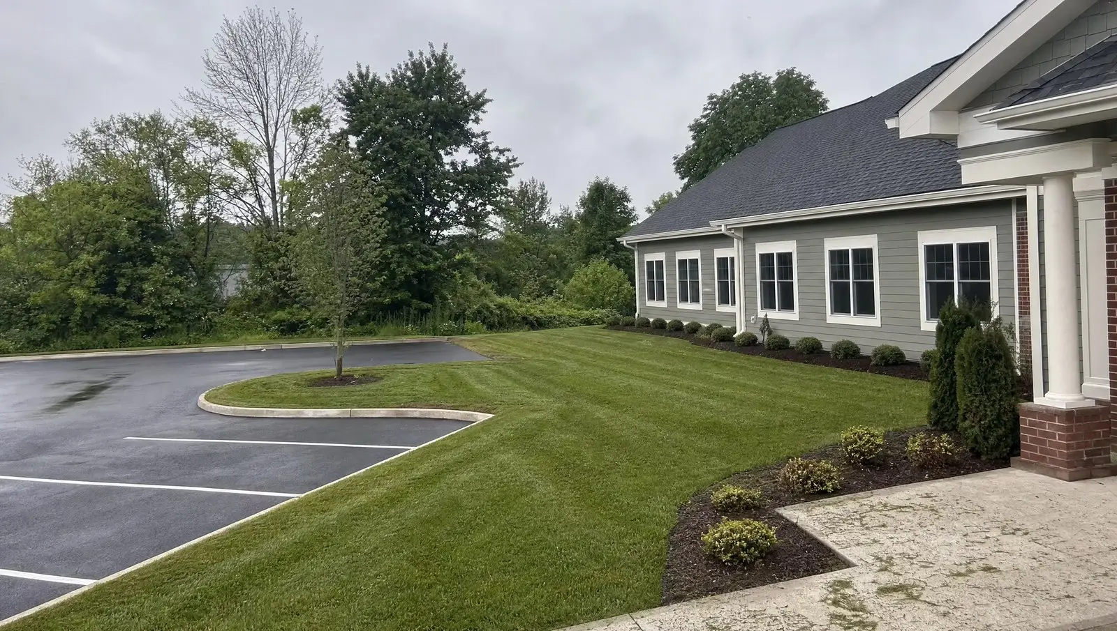Freshly maintained grounds at a Connecticut commercial property with striped mowing lines and edged beds.