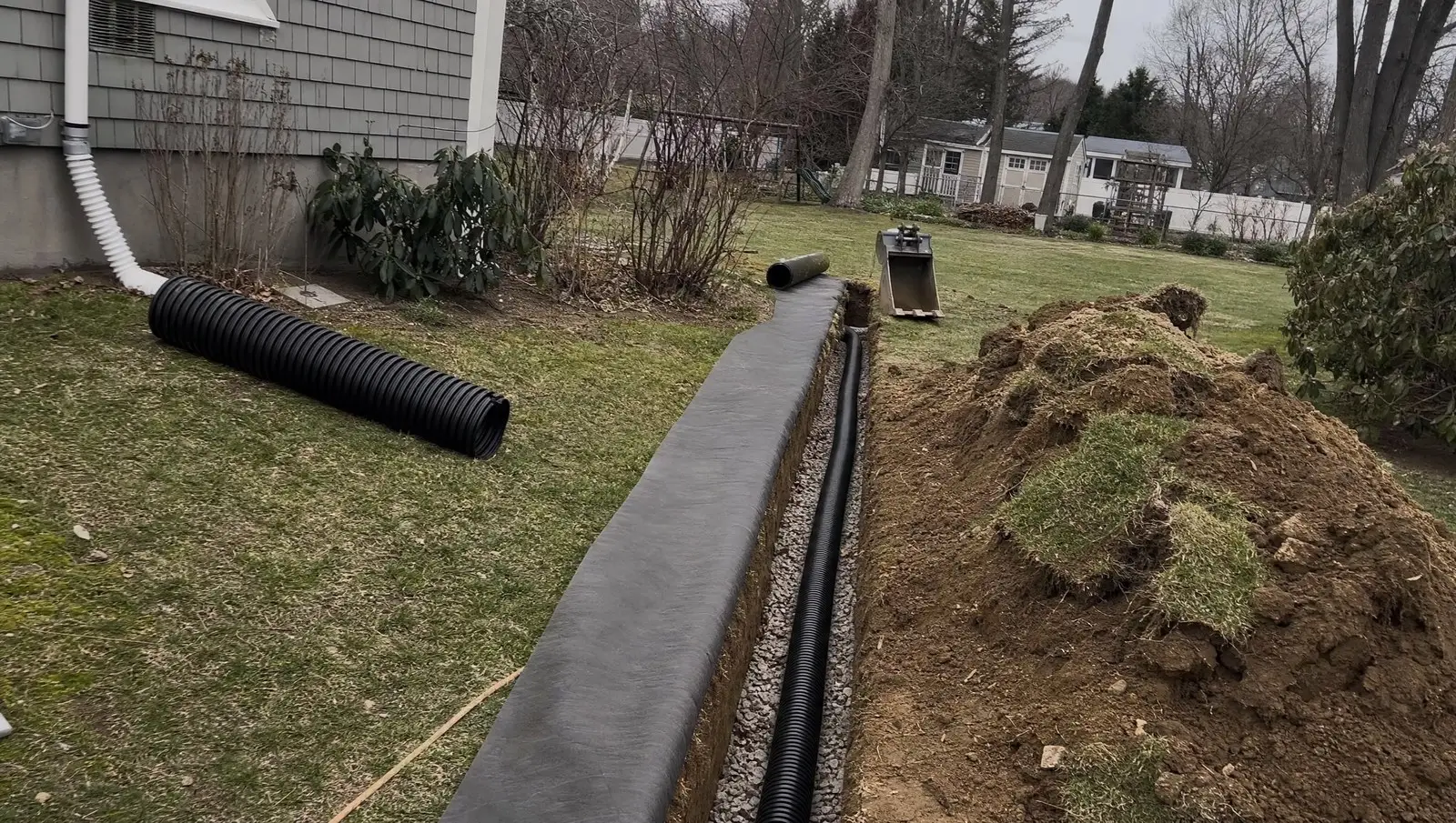 Yard drainage Connecticut trench with perforated pipe on washed stone