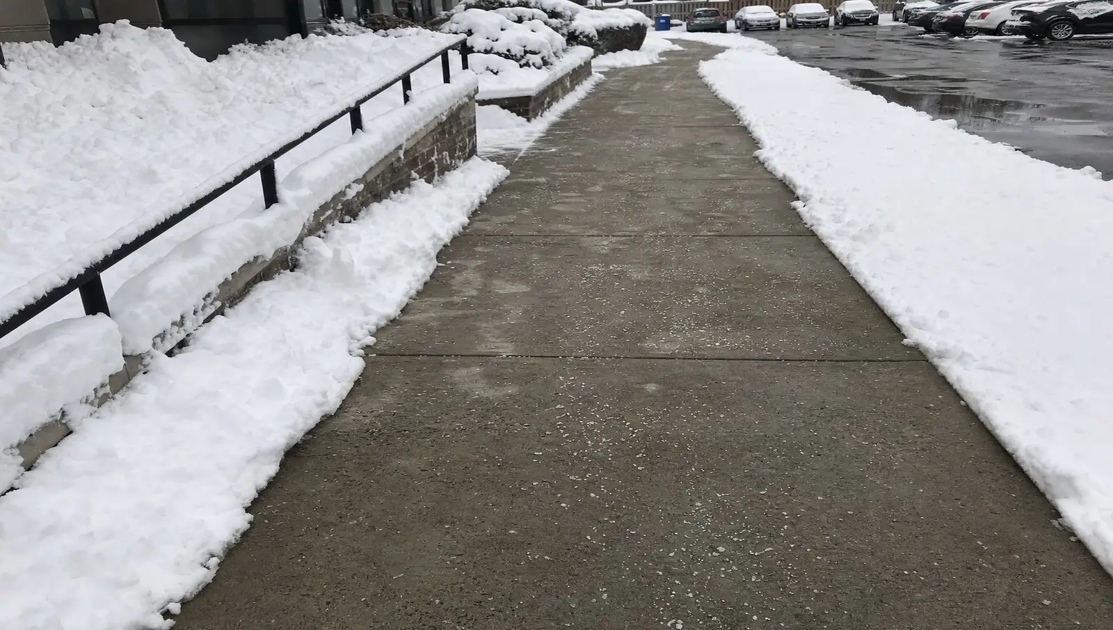 Commercial sidewalk shovelled to bare concrete and salted after a Connecticut snowstorm.