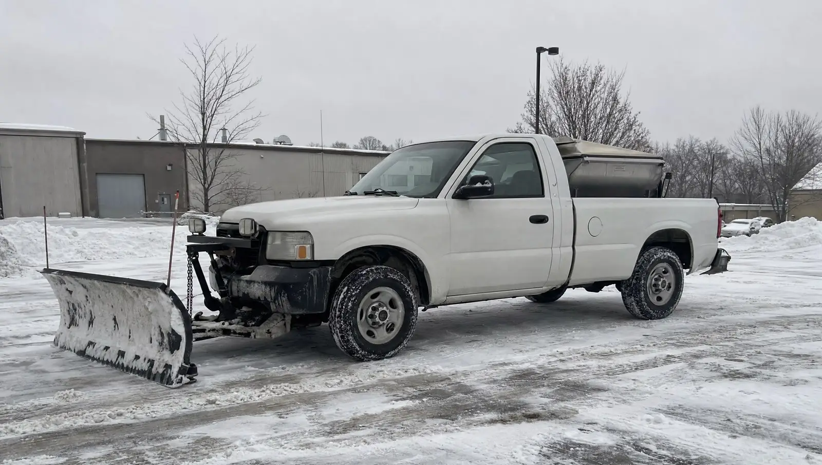 Commercial snow removal Connecticut plow truck with a salt spreader in a snowy lot