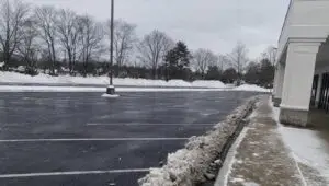 Freshly plowed Connecticut commercial parking lot with snow banks pushed to the perimeter.