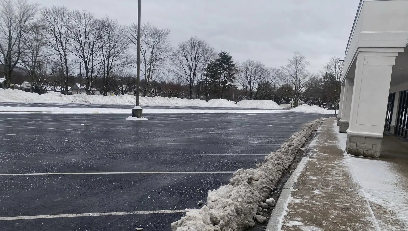 Freshly plowed Connecticut commercial parking lot with snow banks pushed to the perimeter.