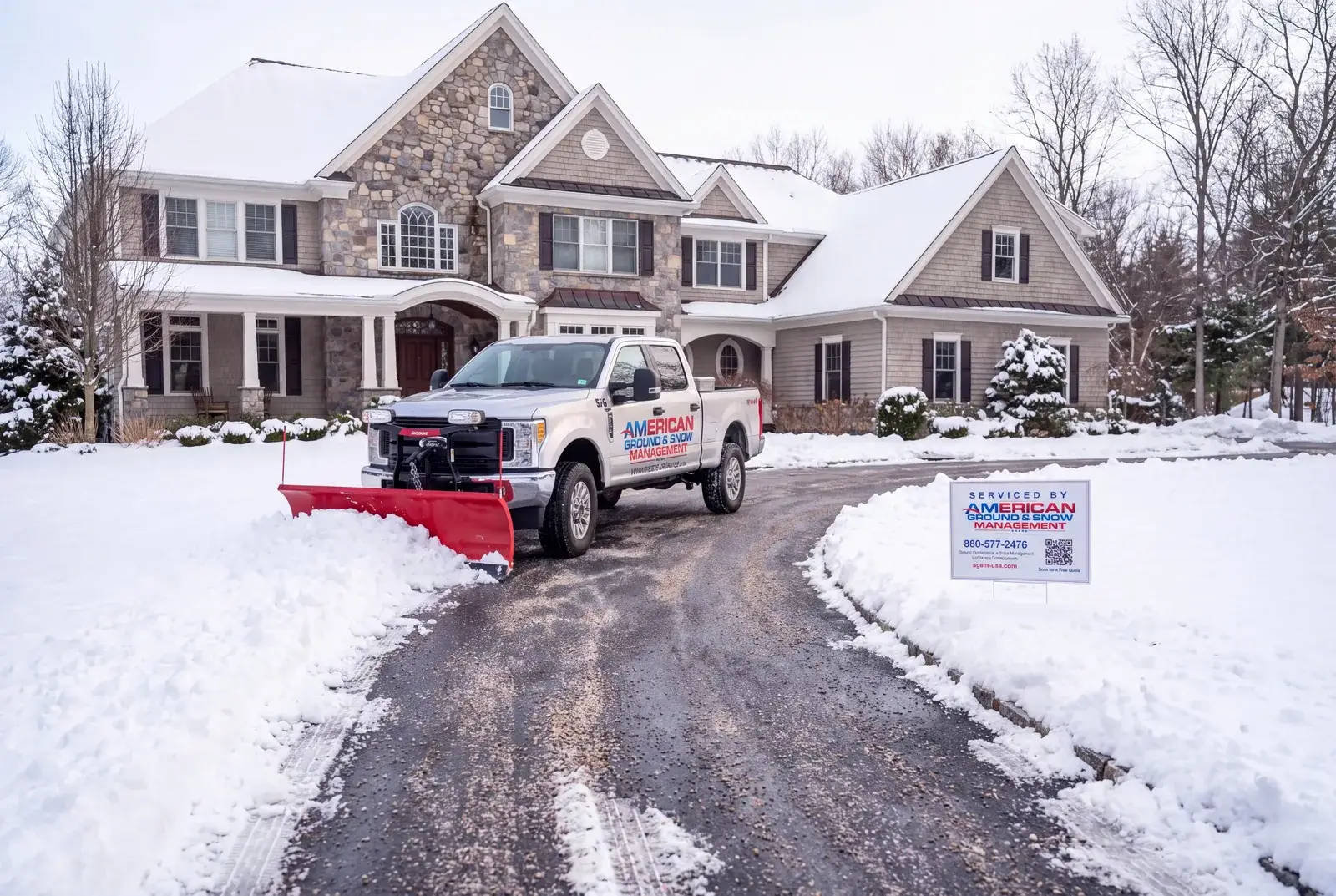 American Ground and Snow plow truck beside a cleared residential driveway in Mystic CT