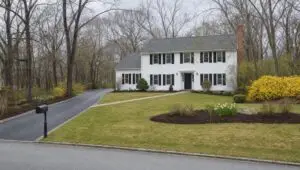 Spring cleanup finished at a white colonial in Connecticut with forsythia in bloom
