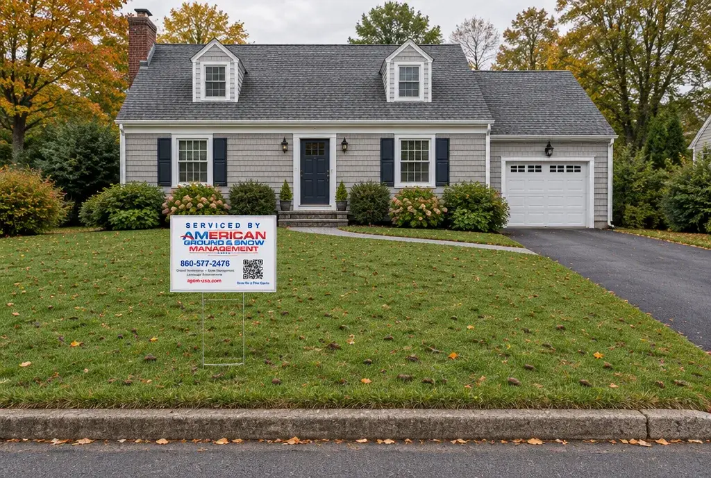 Lawn aeration and overseeding in Groton CT, a freshly core aerated front lawn with an American Ground & Snow Management yard sign