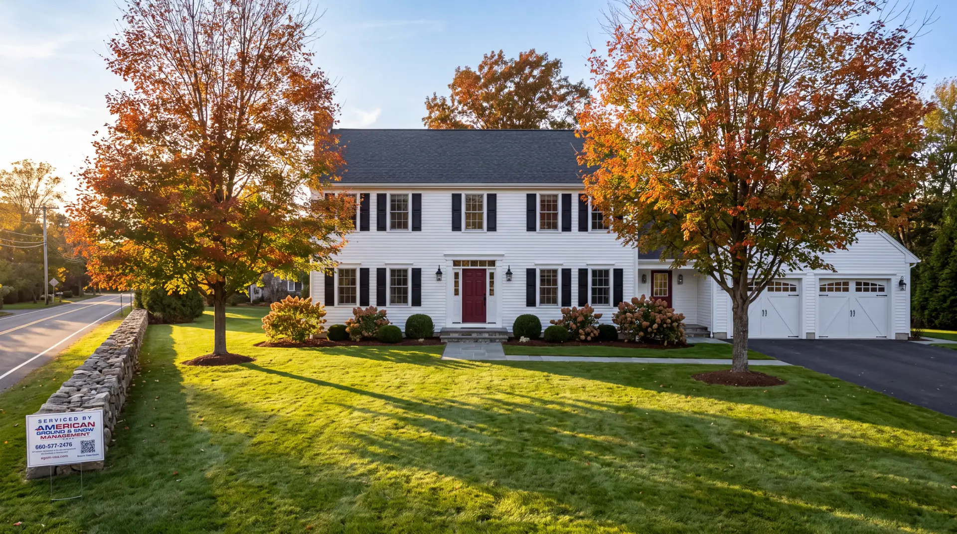 Connecticut colonial after a professional fall cleanup with a clean green lawn, clear beds, and AGSM yard sign