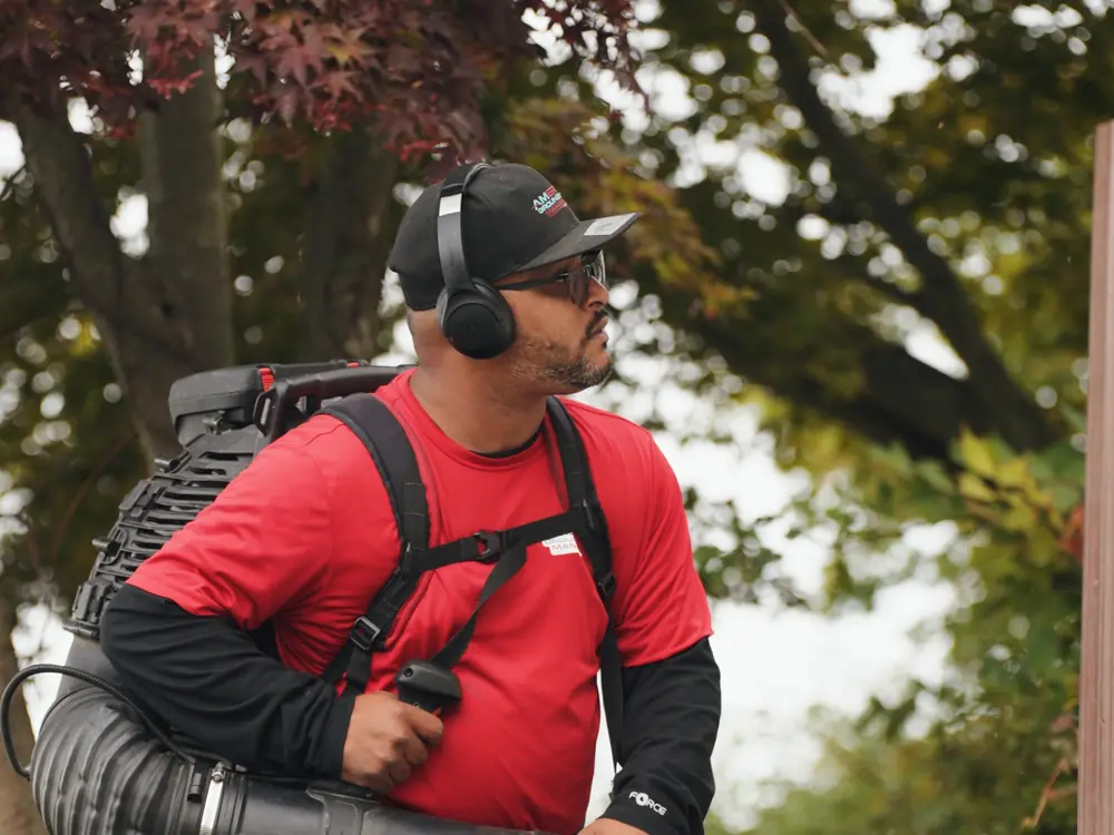 AGSM crew member with a backpack leaf blower during a fall cleanup