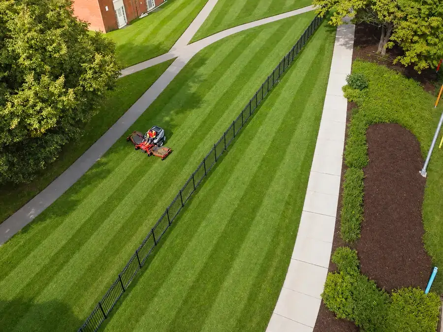 Aerial view of an AGSM crew mowing striped lawns along a property in southeastern Connecticut