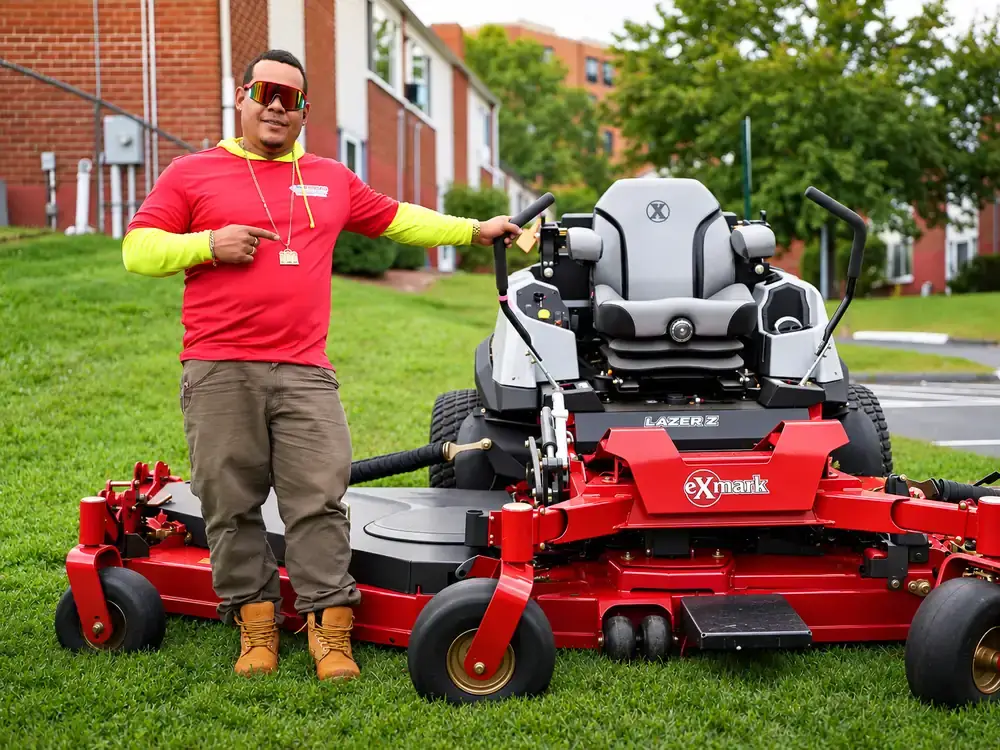 American Ground and Snow Management crew member with a commercial mower