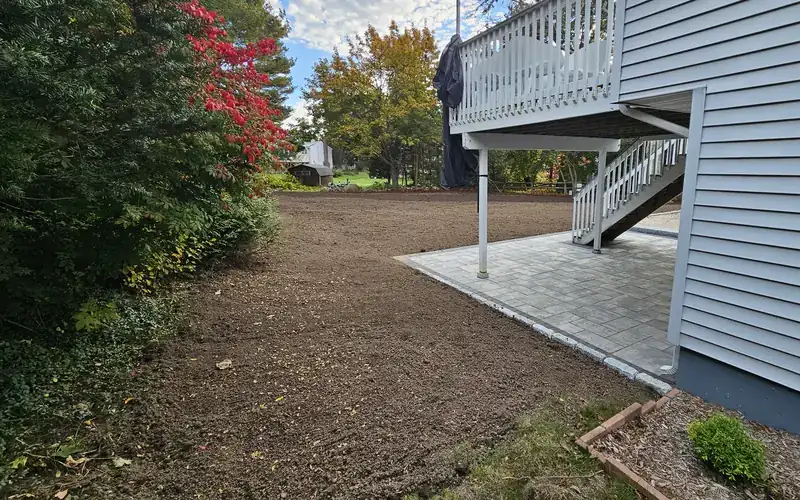 Backyard regraded with fresh topsoil sloping away from the house